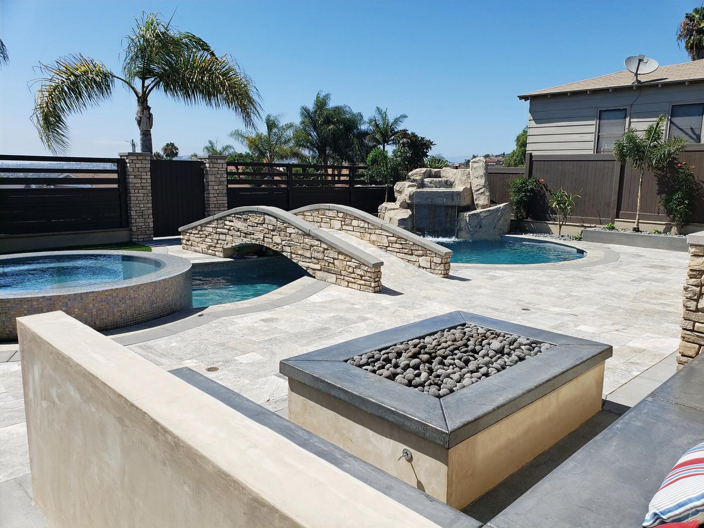 Pool, spa and stone bridge with grotto waterfall