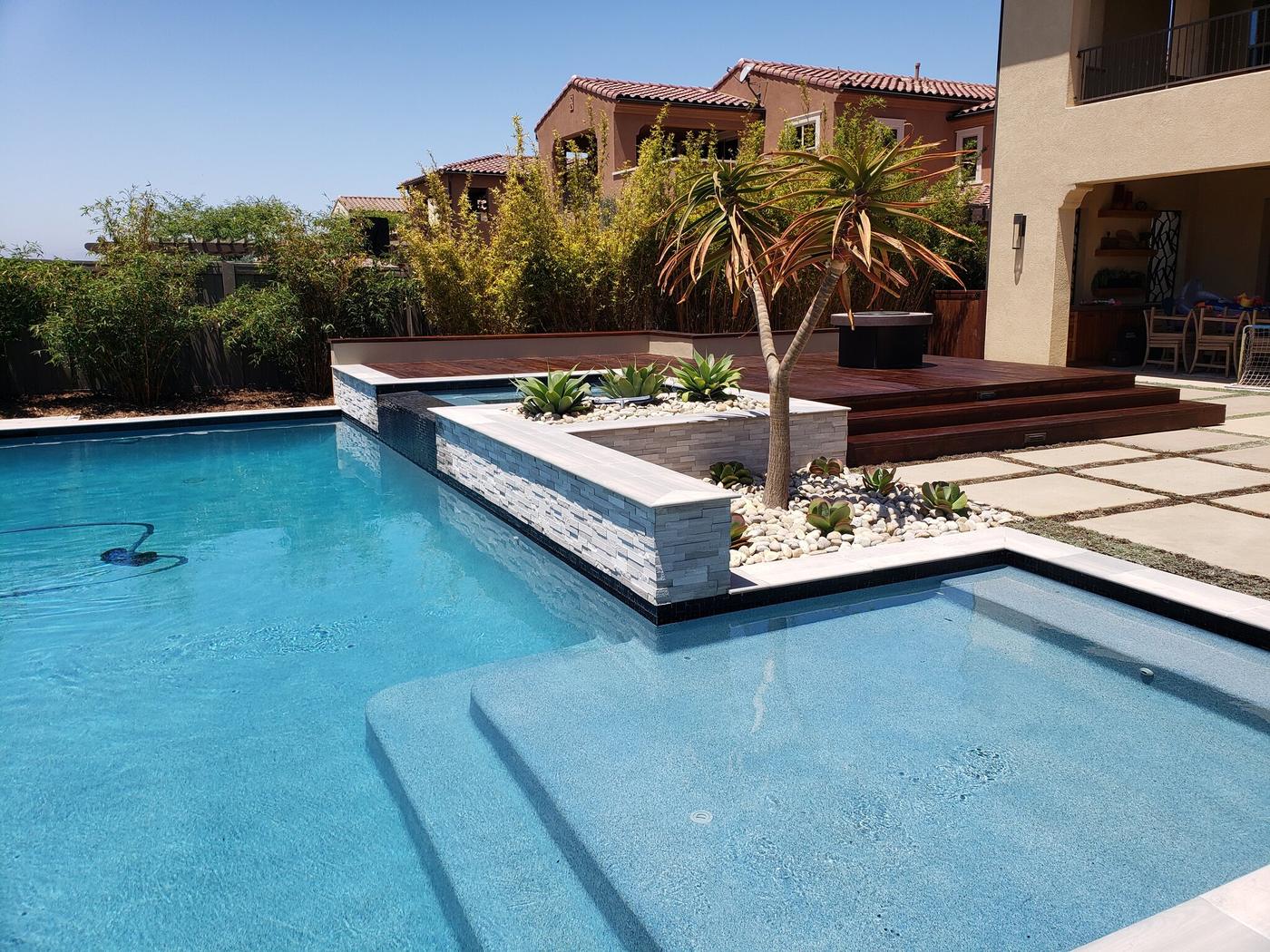 Pool with a raised planter and wood deck